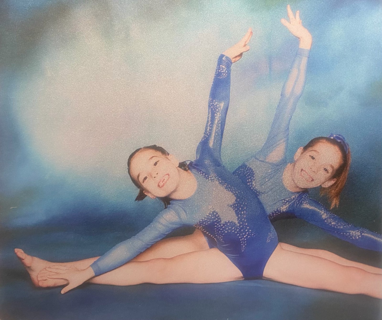 Two gymnasts posing in matching leotards