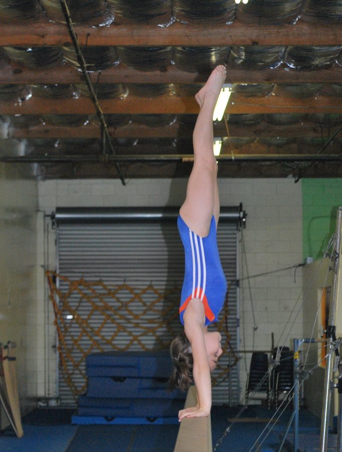 Gymnast holding a handstand on the bars