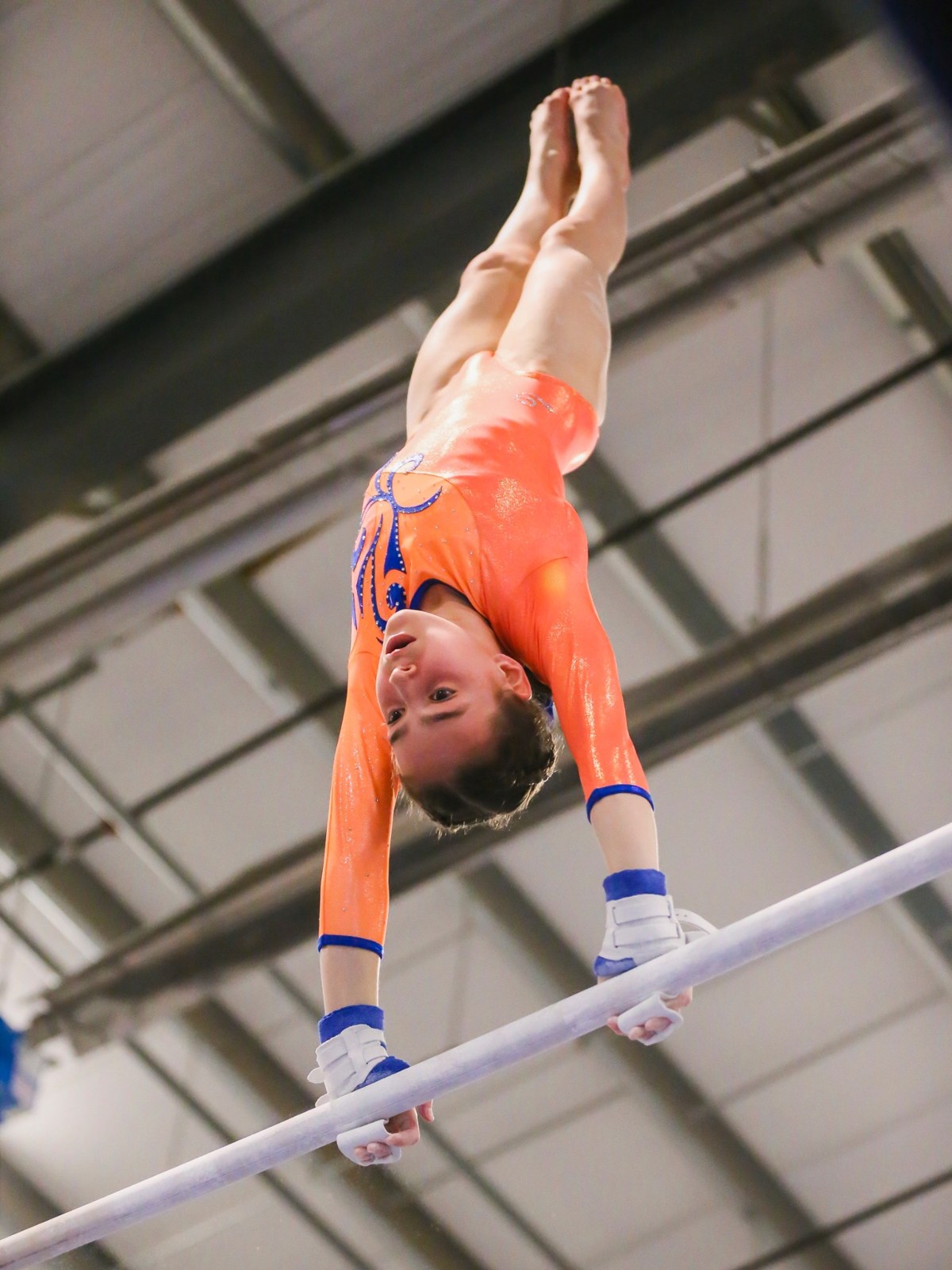 Gymnast holding a handstand on the uneven bars