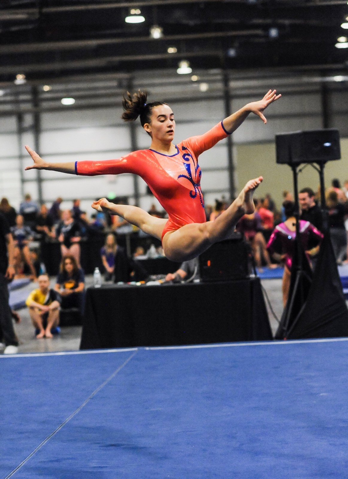 Gymnast performing a split jump during a floor routine