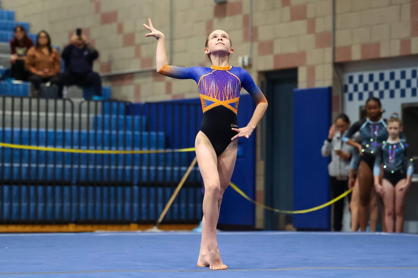 Gymnast finishing a floor exercise pose