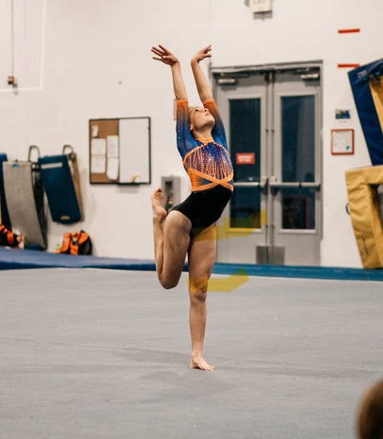 Gymnast practicing a floor routine in the gym