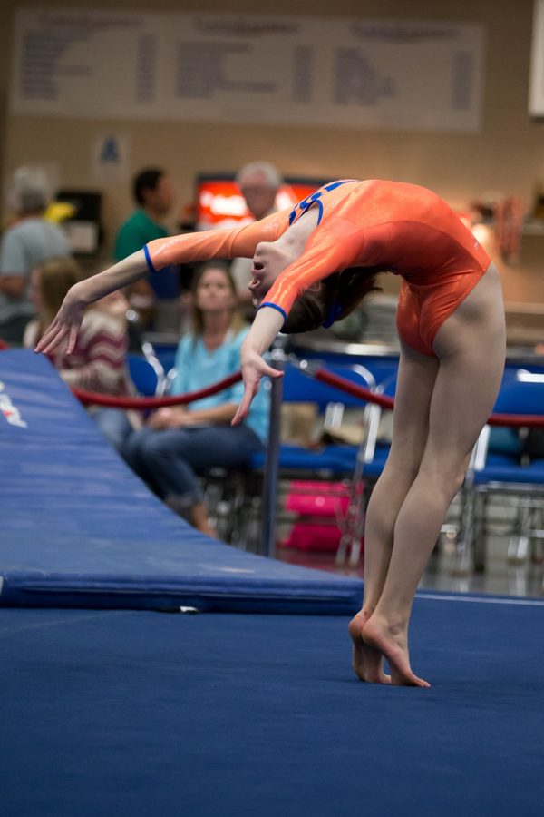 Gymnast performing a backbend on the balance beam