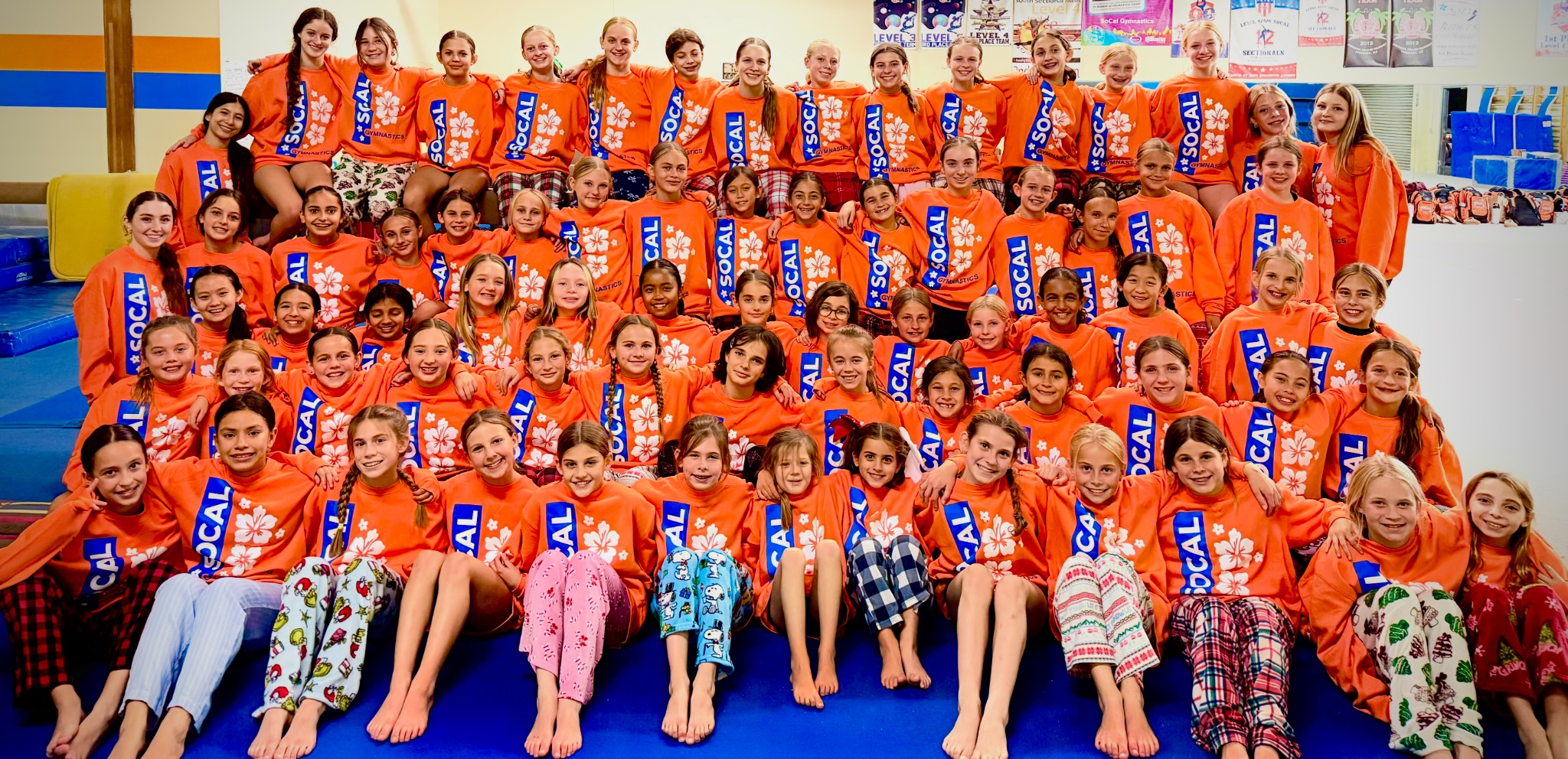 SoCal Gymnastics athletes together in their orange team shirts