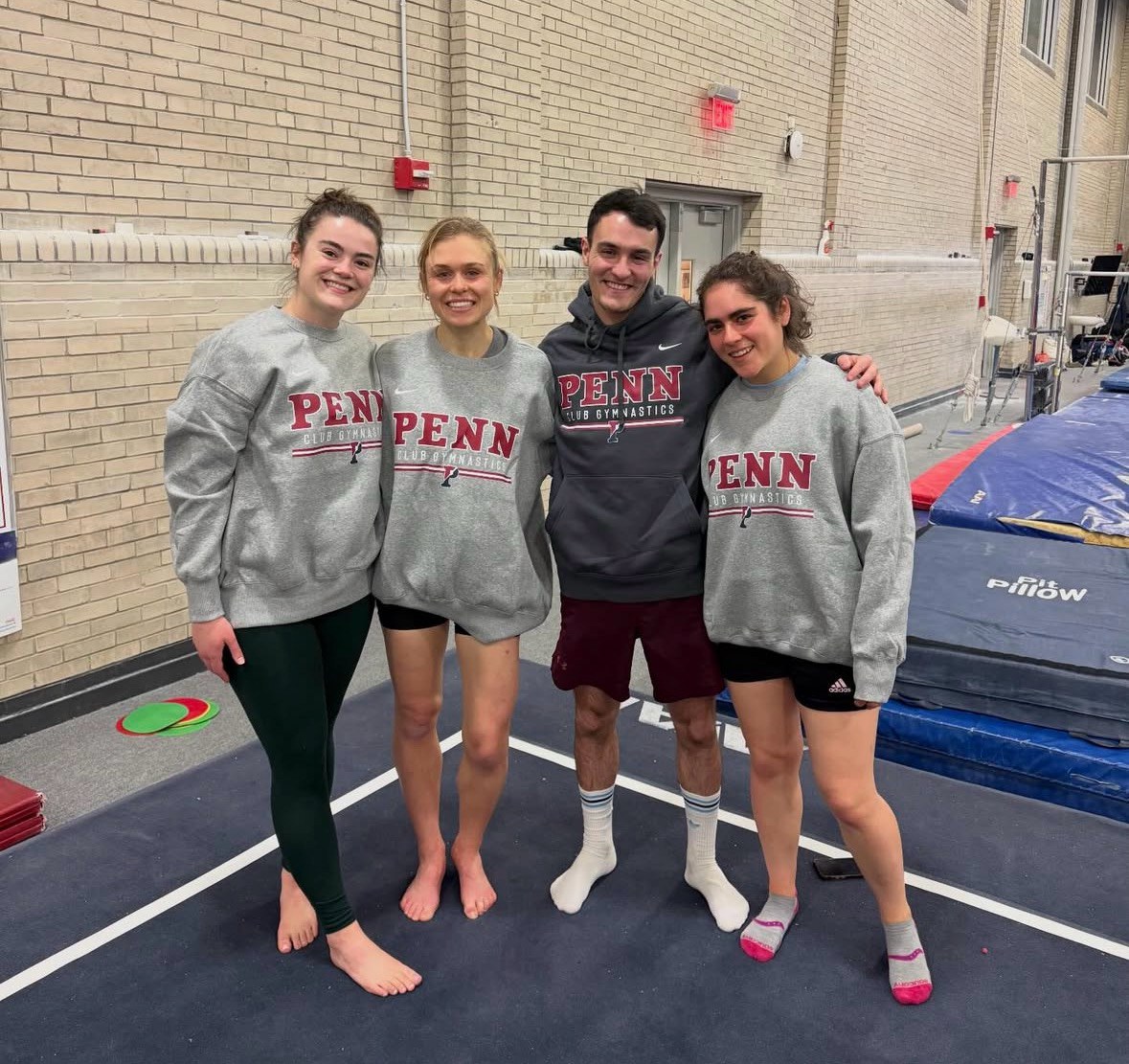 University of Pennsylvania club gymnasts posing together in Penn sweatshirts